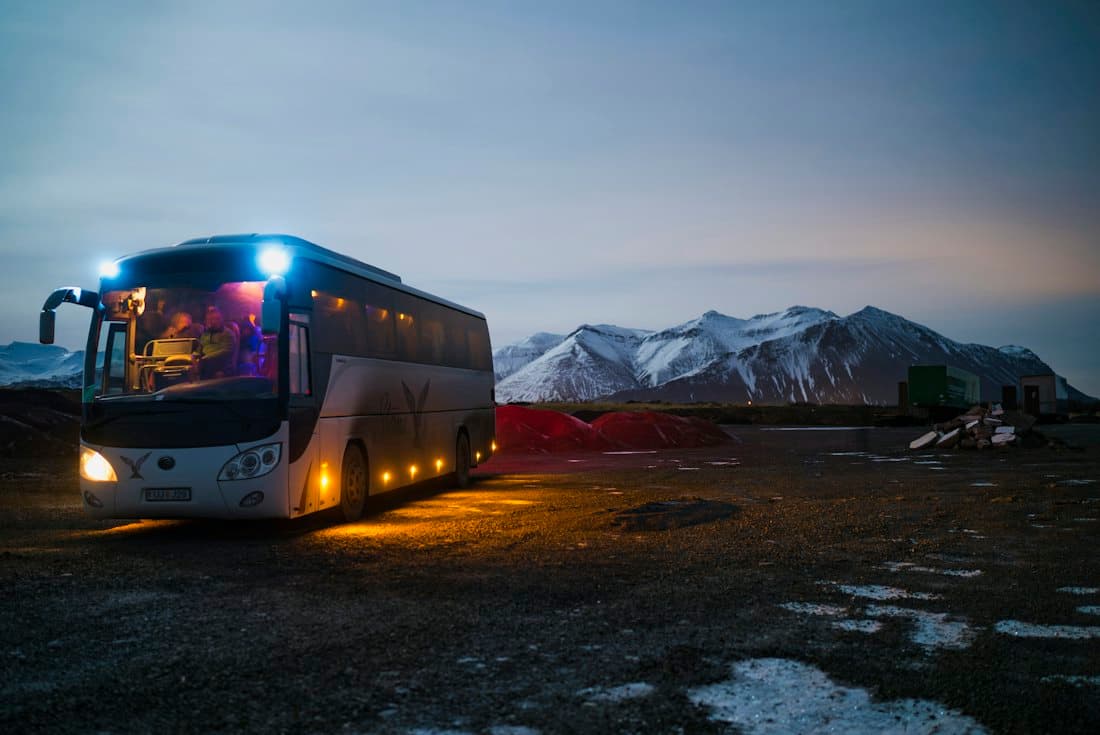 Charter coach bus on an open road at dusk
